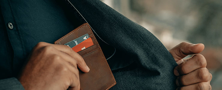 胸ポケットにスマートな財布をしまう男性